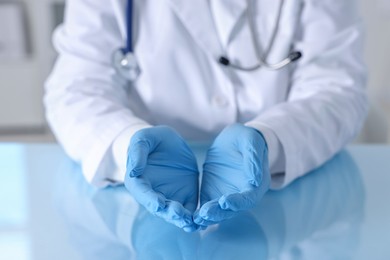 Photo of Doctor holding something at table in clinic, closeup