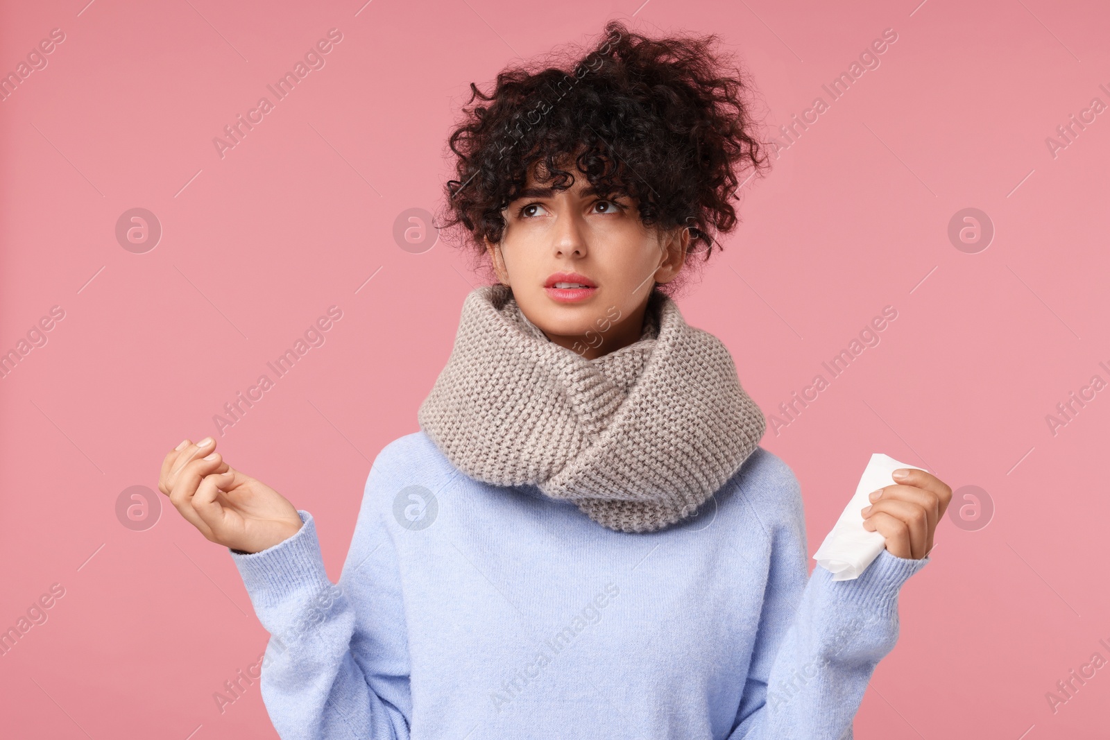 Photo of Cold symptom. Young woman with tissue on pink background