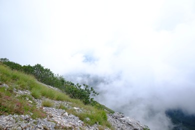 Photo of Picturesque view of rocky mountains covered with clouds