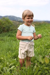 Photo of Happy little girl walking at green meadow. Enjoying beautiful nature