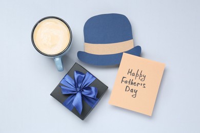 Photo of Greeting card with phrase Happy Father's Day, coffee, gift and paper hat on light background, flat lay