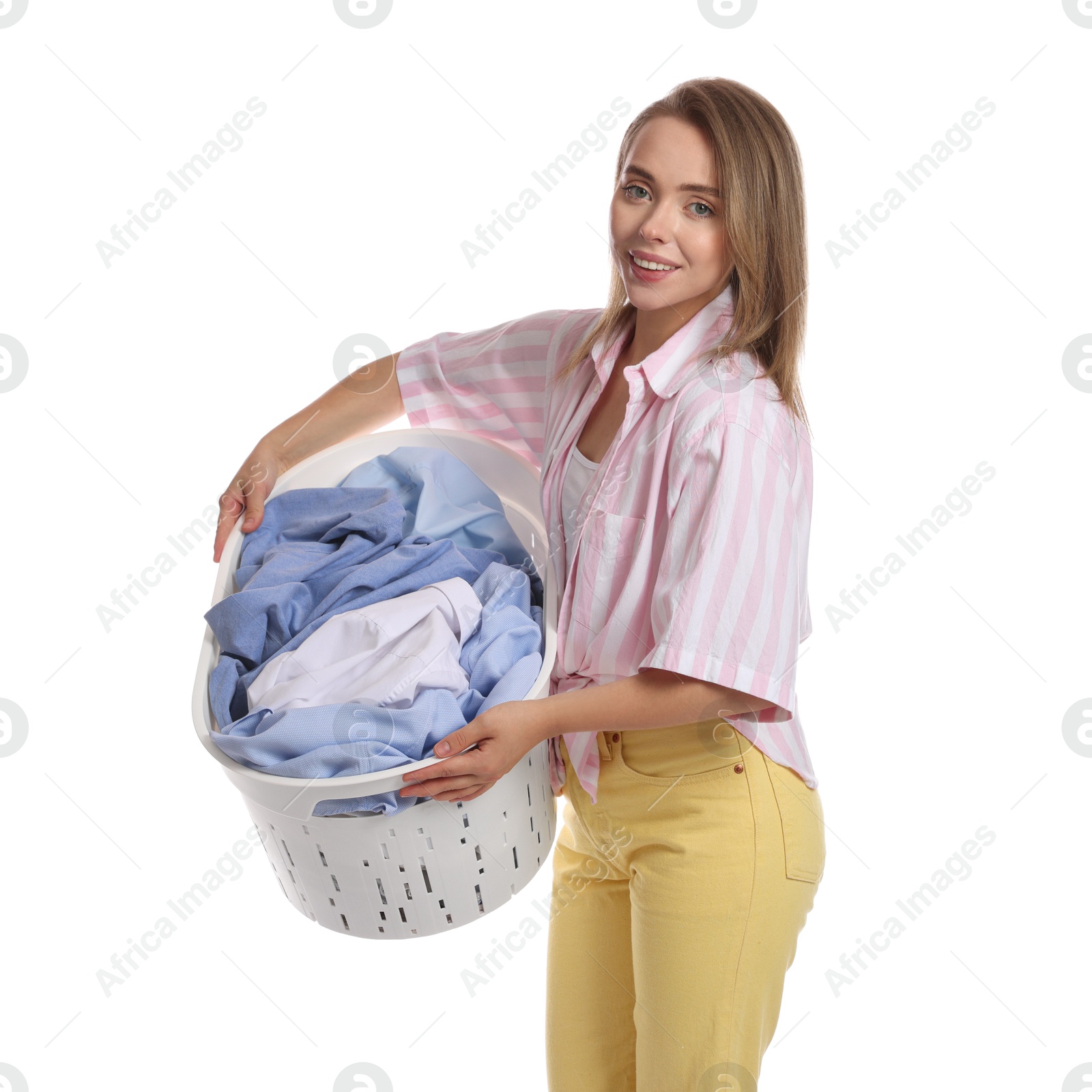 Photo of Happy young housewife with basket full of laundry on white background