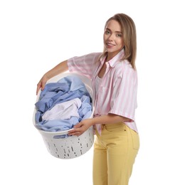 Happy young housewife with basket full of laundry on white background