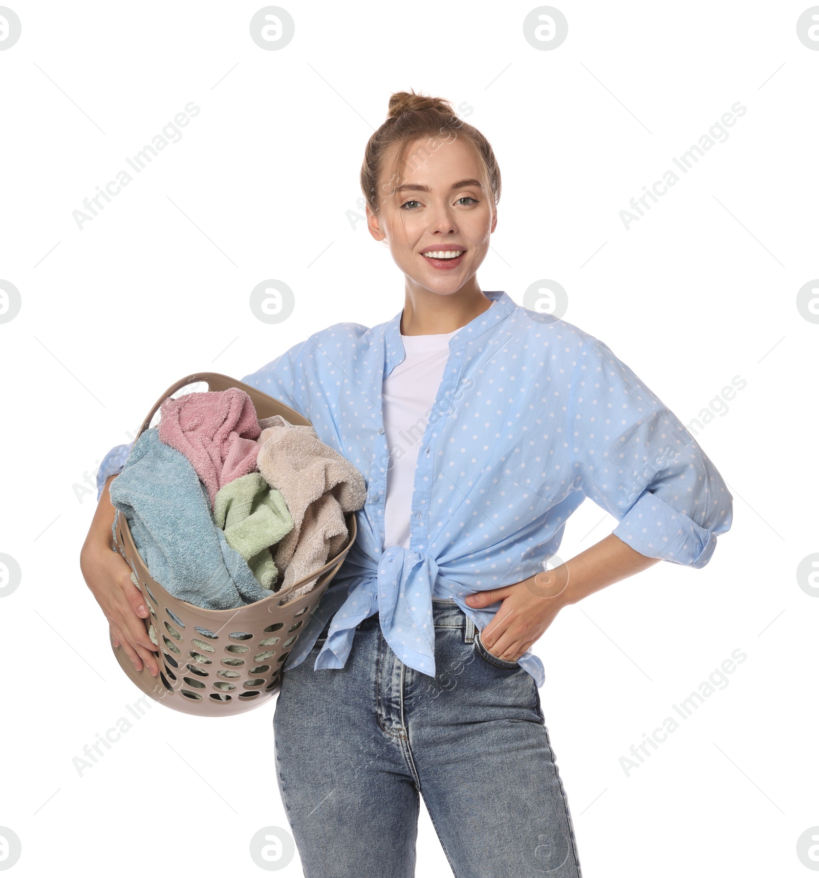 Photo of Happy young housewife with basket full of laundry on white background