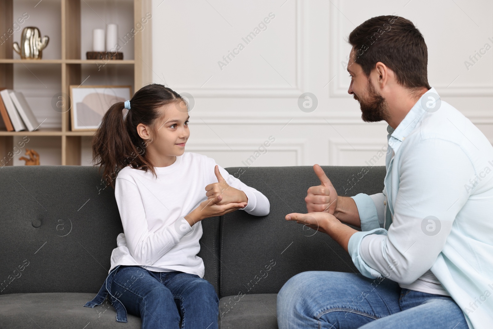 Photo of Man and his daughter using sign language for communication at home