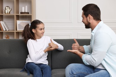 Man and his daughter using sign language for communication at home