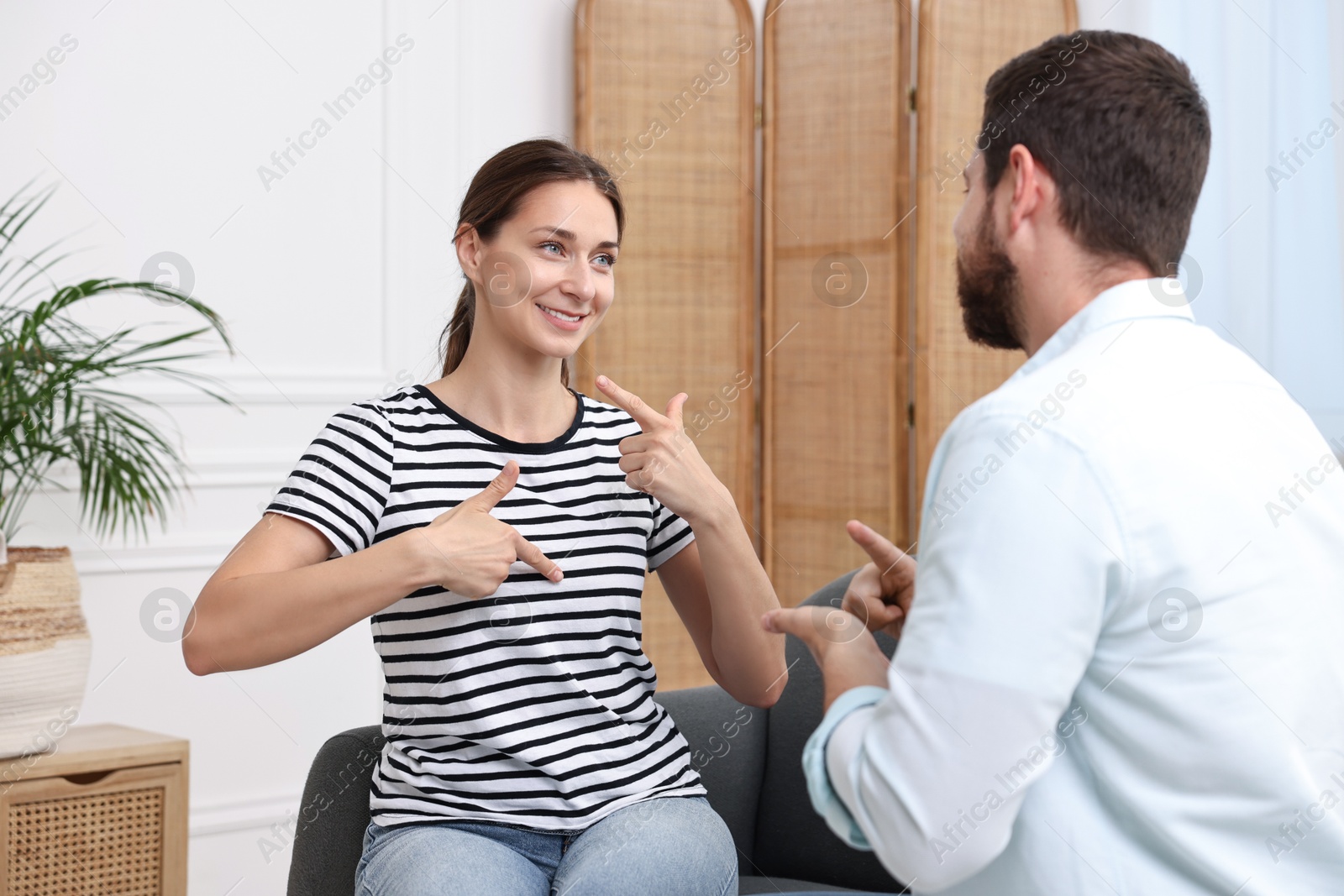 Photo of Man and woman using sign language for communication at home