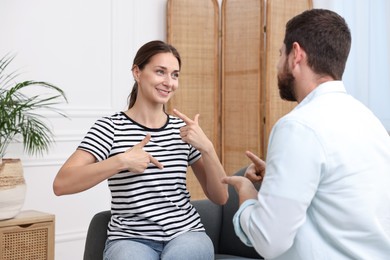 Man and woman using sign language for communication at home