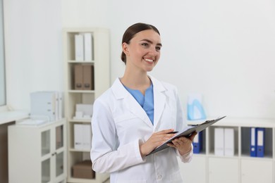 Professional receptionist with clipboard working in hospital