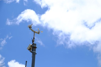 Photo of Anemometer on pole against blue sky, space for text