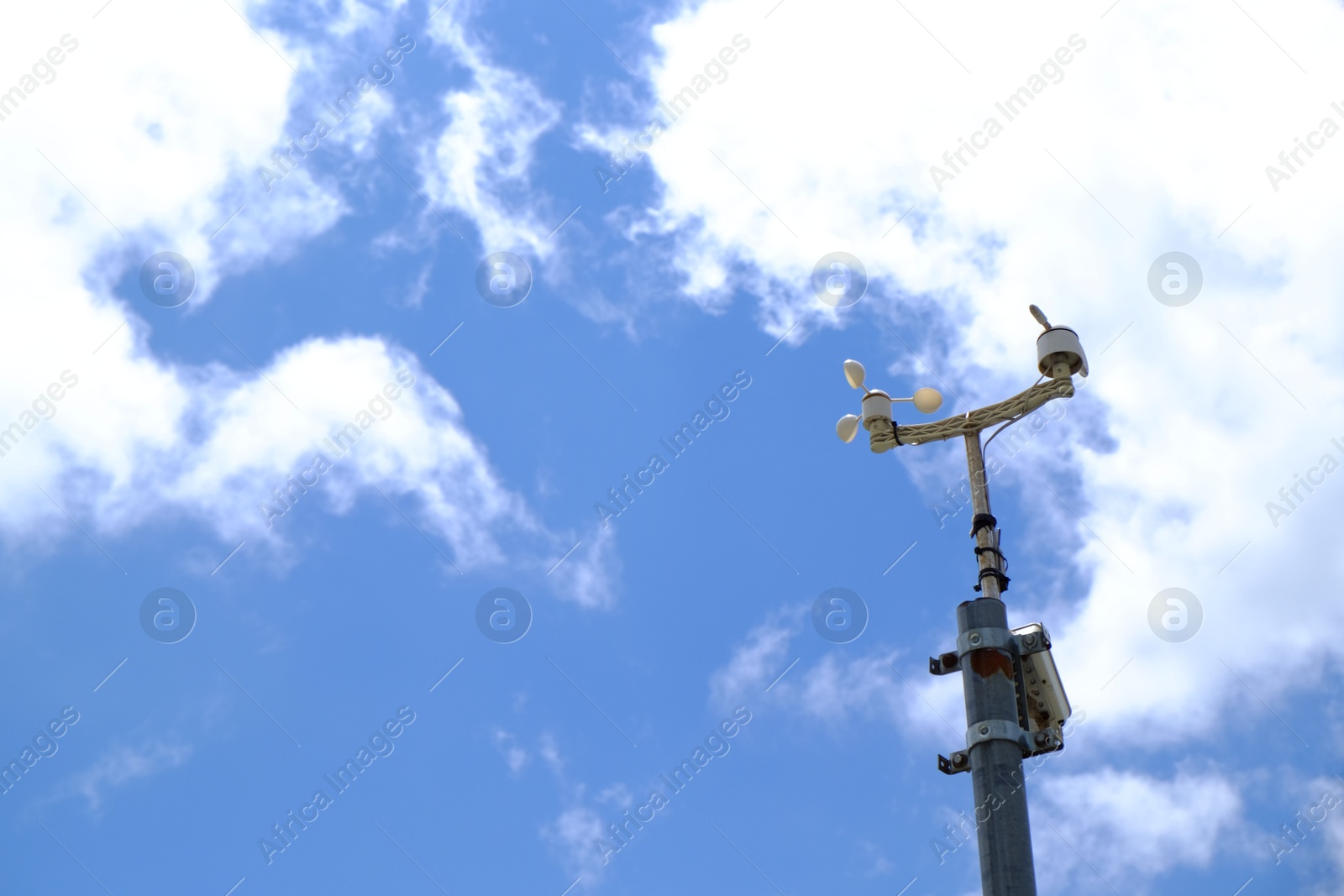 Photo of Anemometer on pole against blue sky, space for text