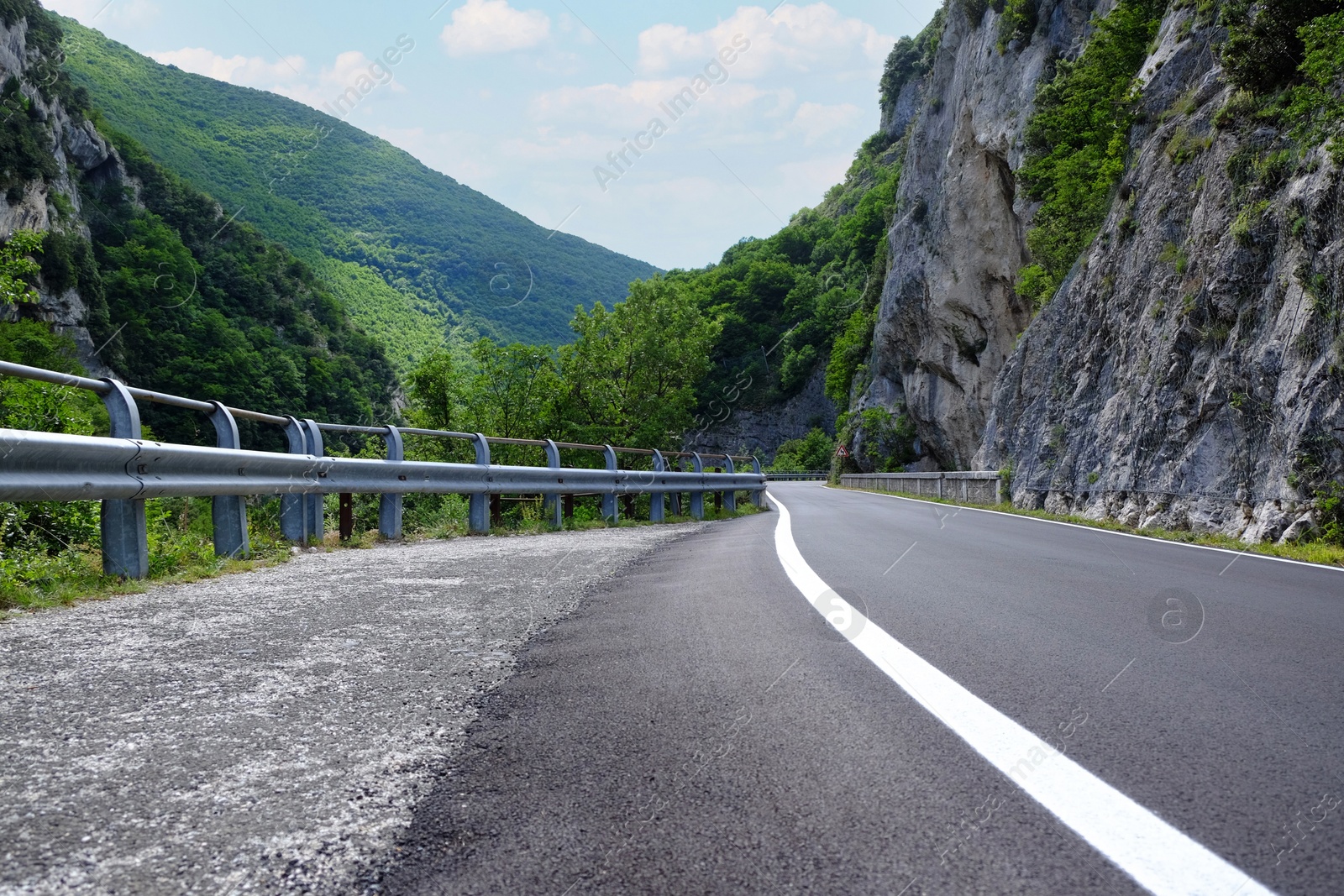 Photo of Picturesque view of rocky cliff and asphalt road in mountains