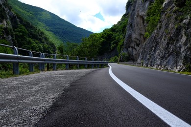 Photo of Picturesque view of rocky cliff and asphalt road in mountains