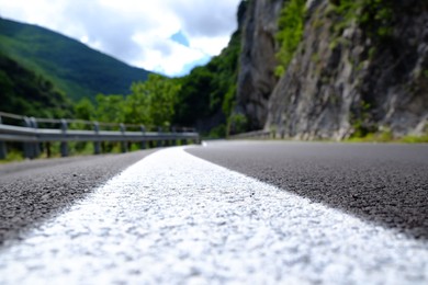 Photo of Picturesque view of rocky cliff and asphalt road in mountains