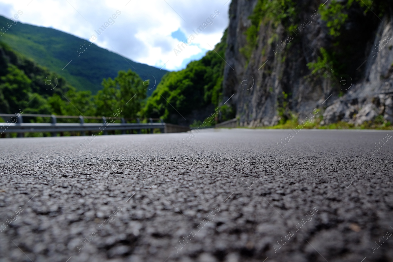 Photo of Picturesque view of rocky cliff and asphalt road in mountains