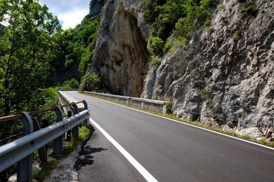 Picturesque view of rocky cliff and asphalt road in mountains