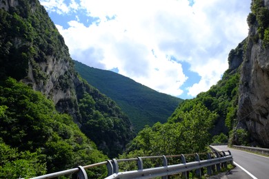 Photo of Picturesque view of rocky cliff and asphalt road in mountains