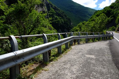 Photo of Picturesque view of rocky cliff and asphalt road in mountains