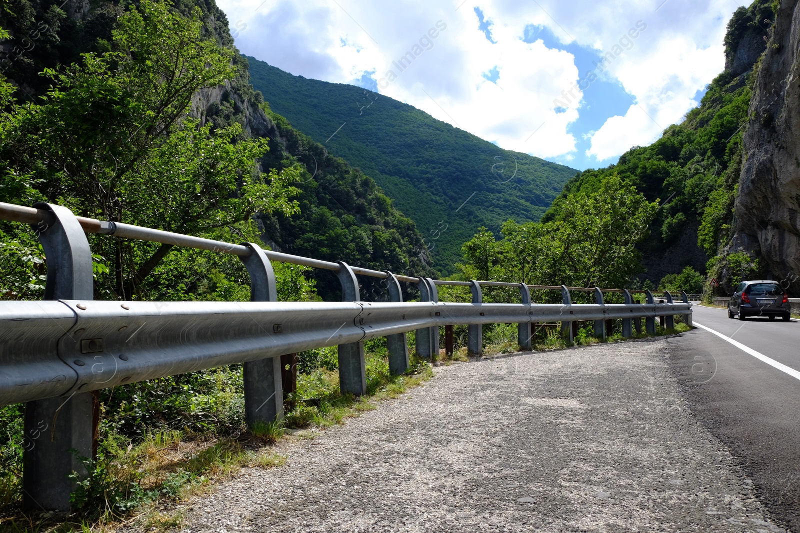 Photo of Picturesque view of rocky cliff and asphalt road in mountains