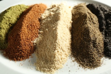 Different superfood powders on plate, closeup view