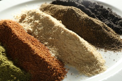 Different superfood powders on plate, closeup view