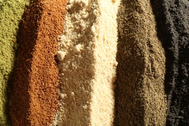 Different superfood powders as background, closeup view