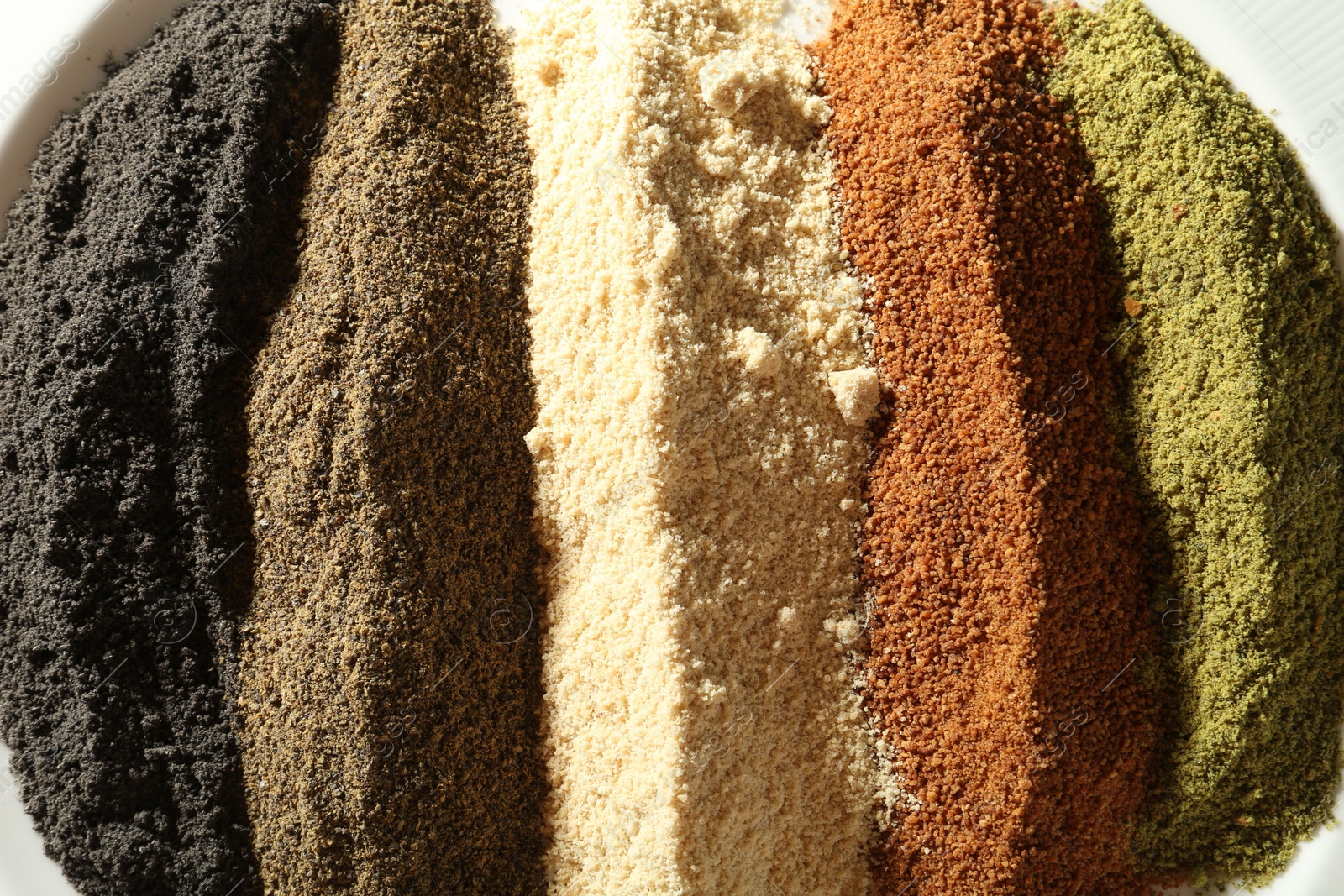 Photo of Different superfood powders on plate, closeup view