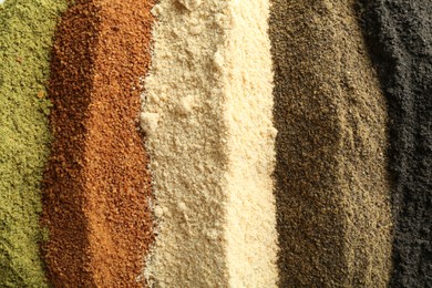 Photo of Different superfood powders as background, closeup view