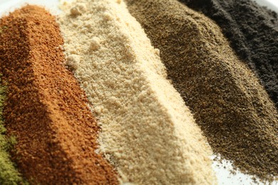 Photo of Different superfood powders on plate, closeup view