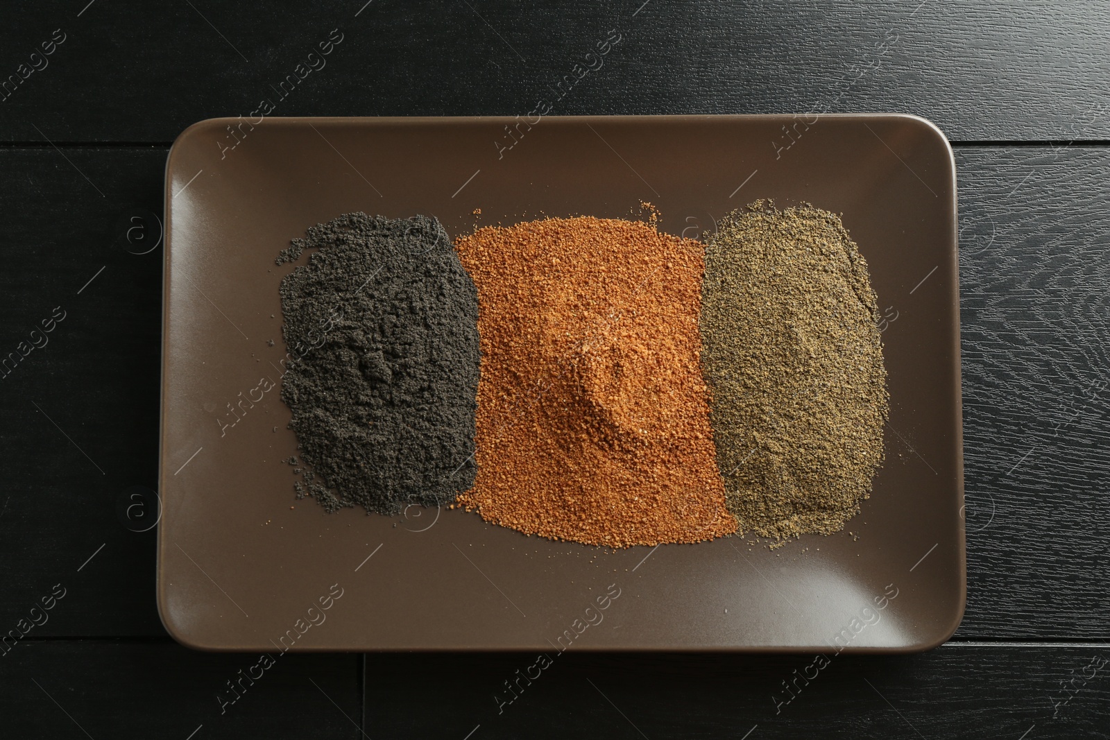 Photo of Different superfood powders on black wooden table, top view