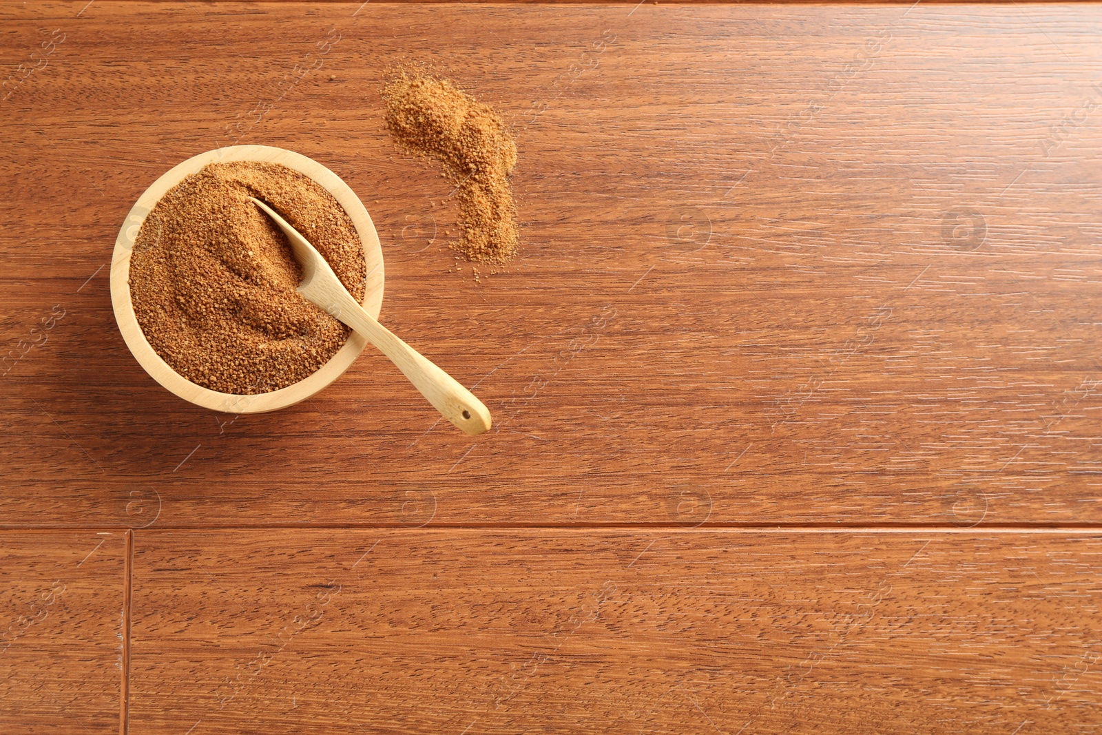 Photo of Superfood powder in bowl and spoon on wooden table, top view. Space for text