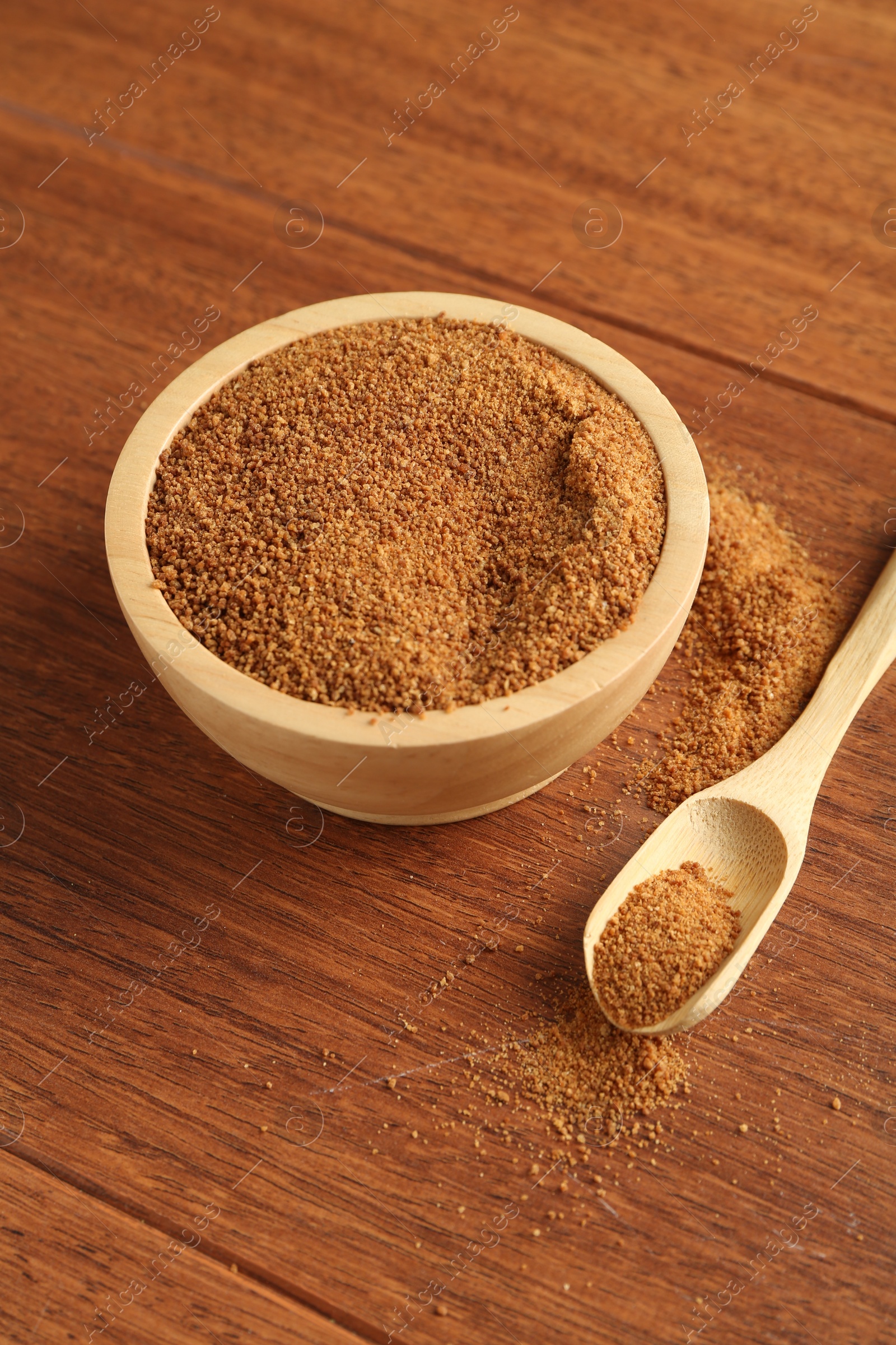 Photo of Superfood powder in bowl and spoon on wooden table