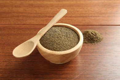 Photo of Superfood powder in bowl and spoon on wooden table, closeup