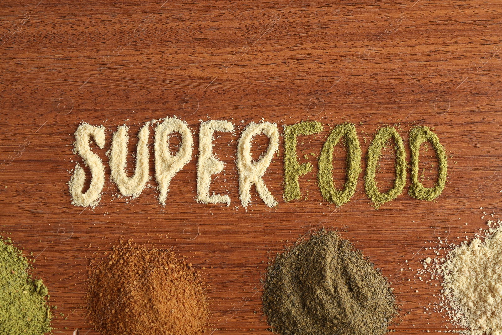 Photo of Word Superfood and different healthy powders on wooden table, flat lay