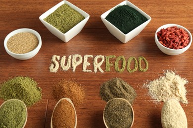 Word Superfood and different healthy powders on wooden table