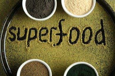 Photo of Word Superfood and different healthy powders on table, top view