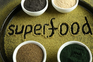 Word Superfood and different healthy powders on table, closeup