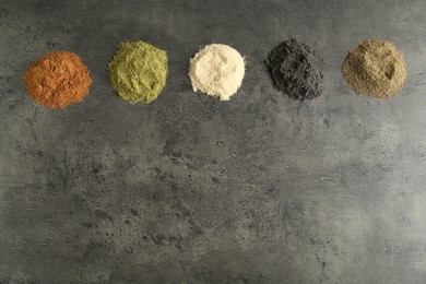 Photo of Different superfood powders on grey table, flat lay. Space for text