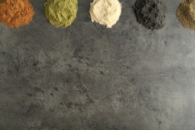 Photo of Different superfood powders on grey table, flat lay. Space for text