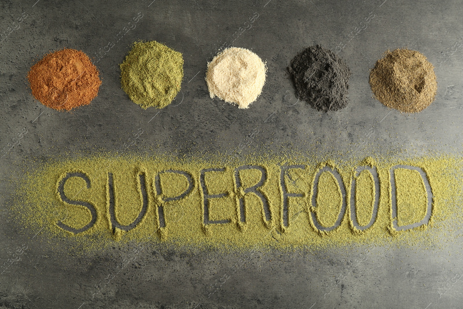 Photo of Word Superfood and different healthy powders on grey table, flat lay