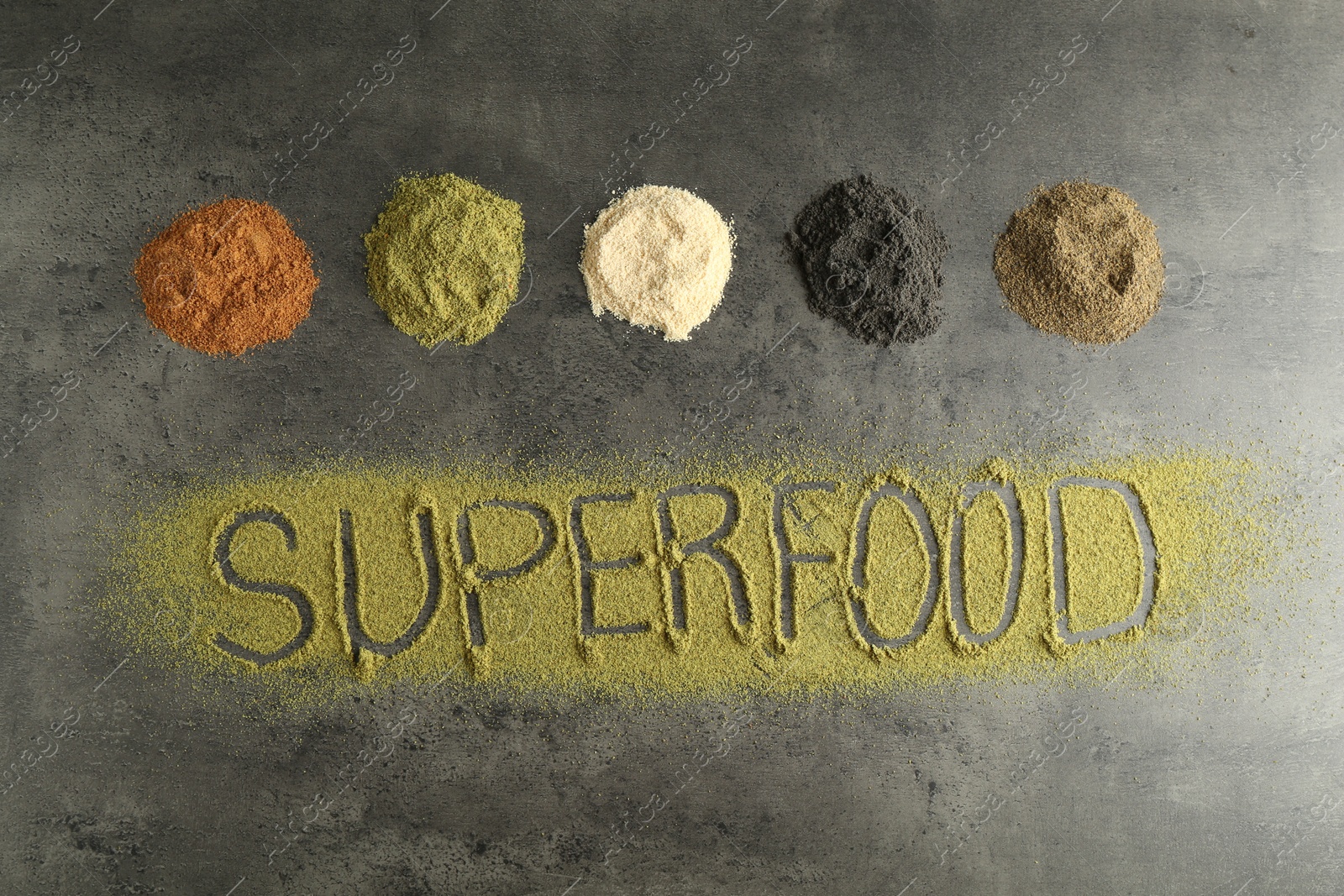 Photo of Word Superfood and different healthy powders on grey table, flat lay