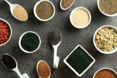 Photo of Many different healthy superfoods on grey table, flat lay