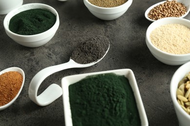 Photo of Many different healthy superfoods on grey table, closeup