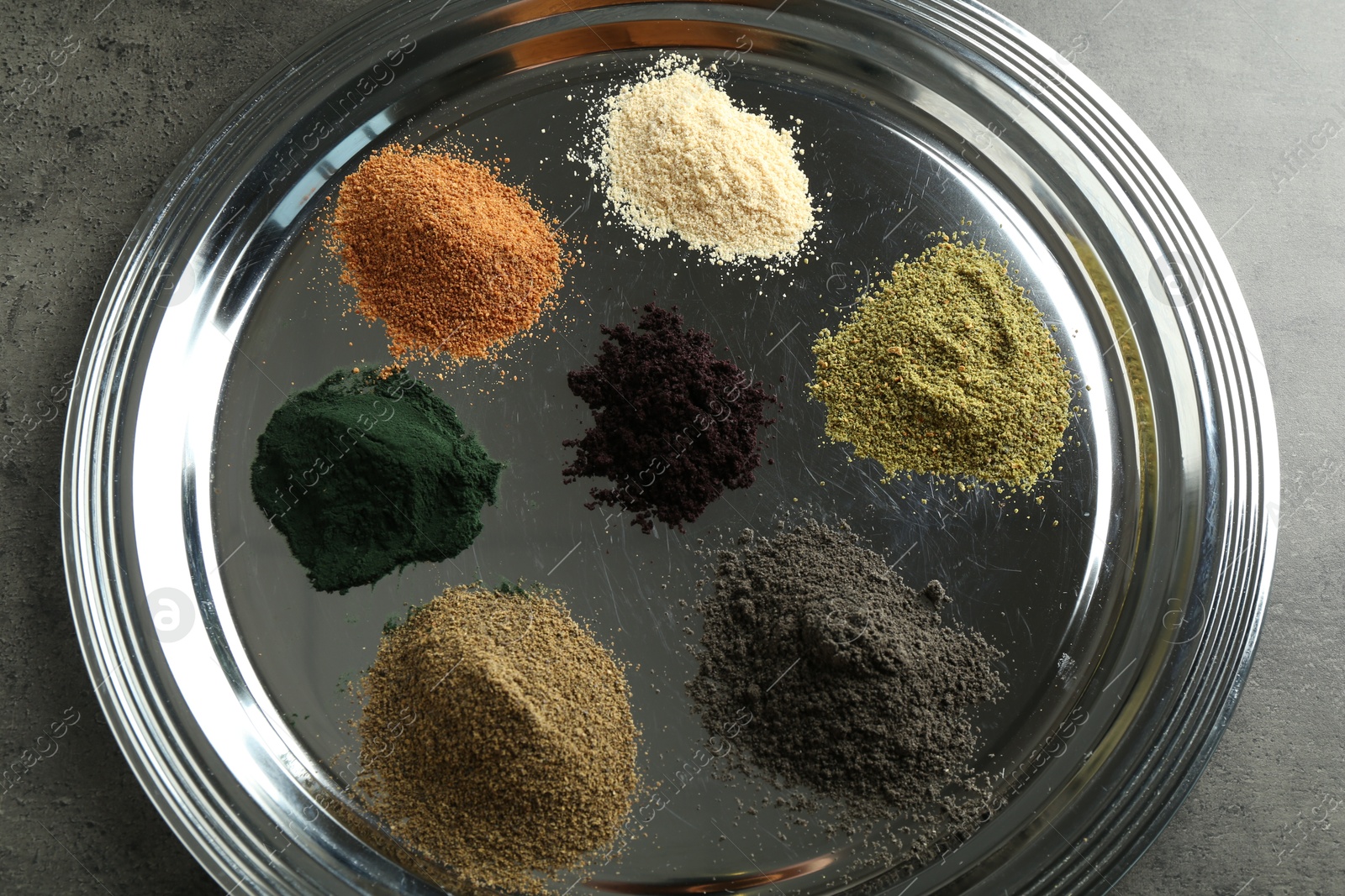 Photo of Different superfood powders on grey table, above view