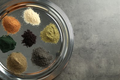 Photo of Different superfood powders on grey table, top view. Space for text