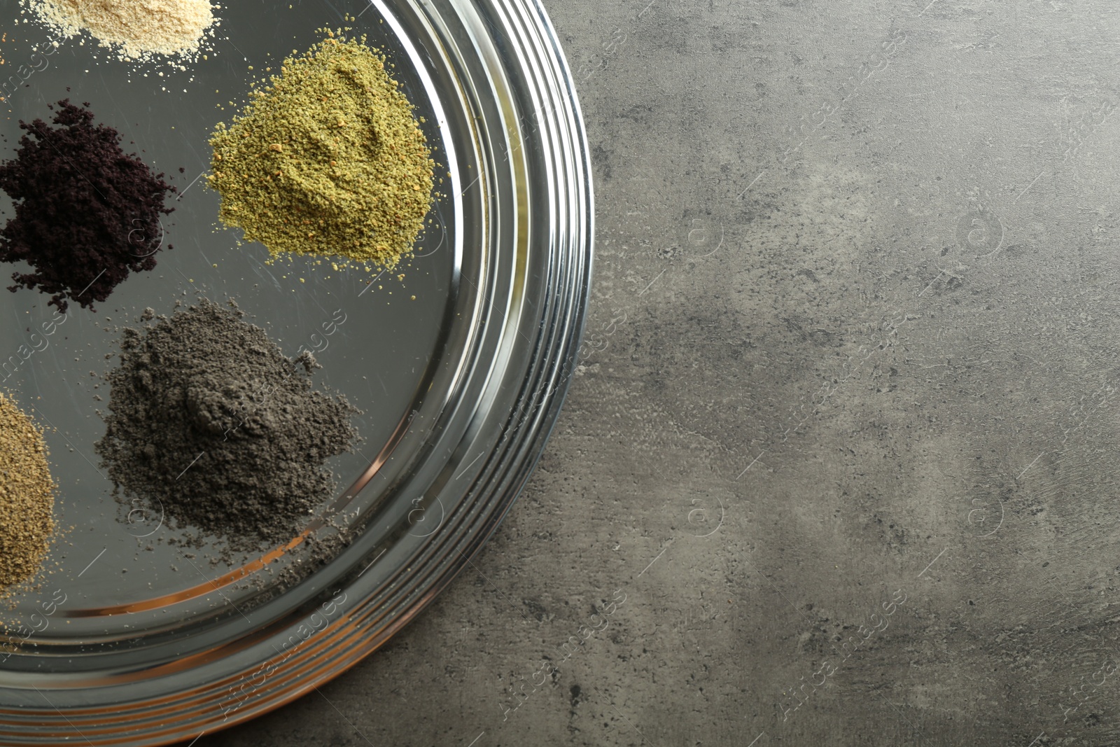 Photo of Different superfood powders on grey table, top view. Space for text