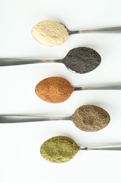 Photo of Different superfood powders in spoons on white background, flat lay