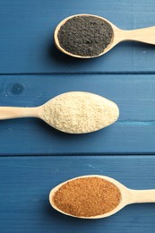 Photo of Different superfood powders in spoons on blue wooden table, flat lay