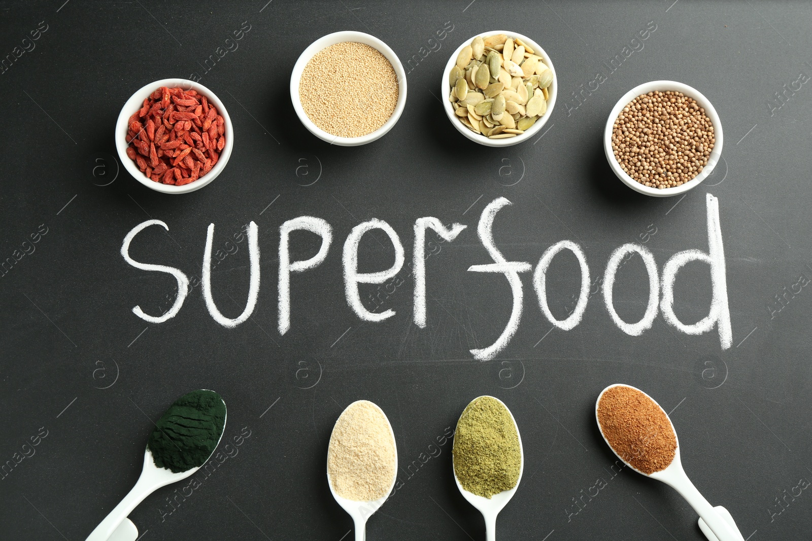 Photo of Word Superfood and different healthy powders on black table, flat lay