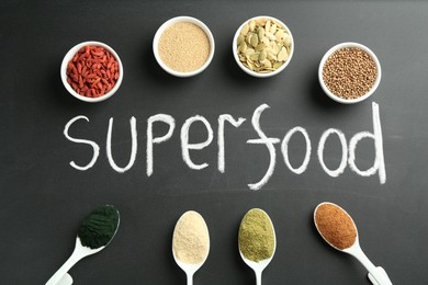 Photo of Word Superfood and different healthy powders on black table, flat lay